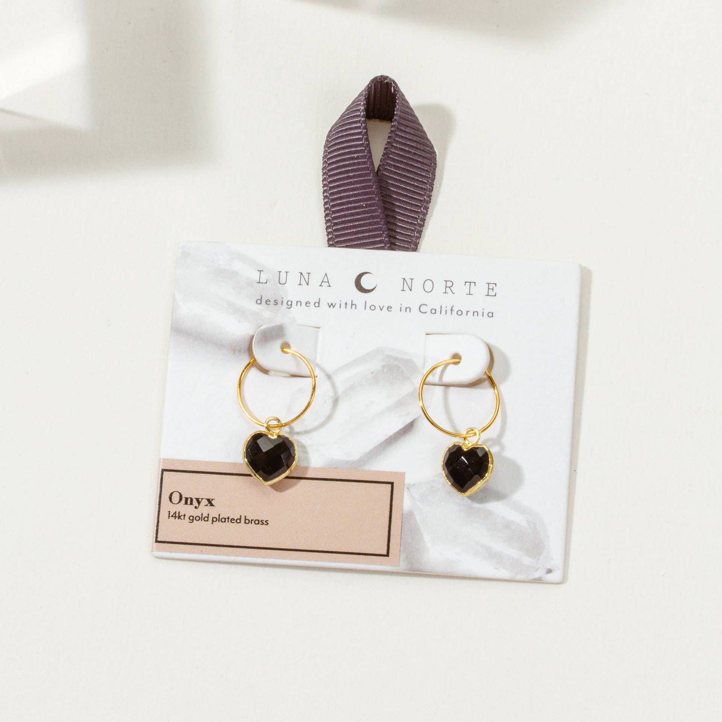Heart-shaped earrings on a Luna Norte branded card with a white background