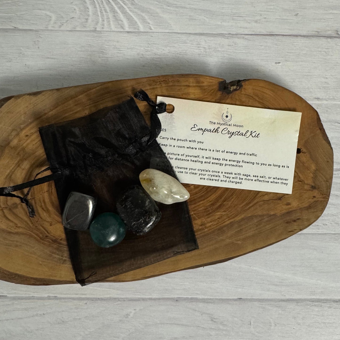 Crystal kit with stones and a card on a wooden board