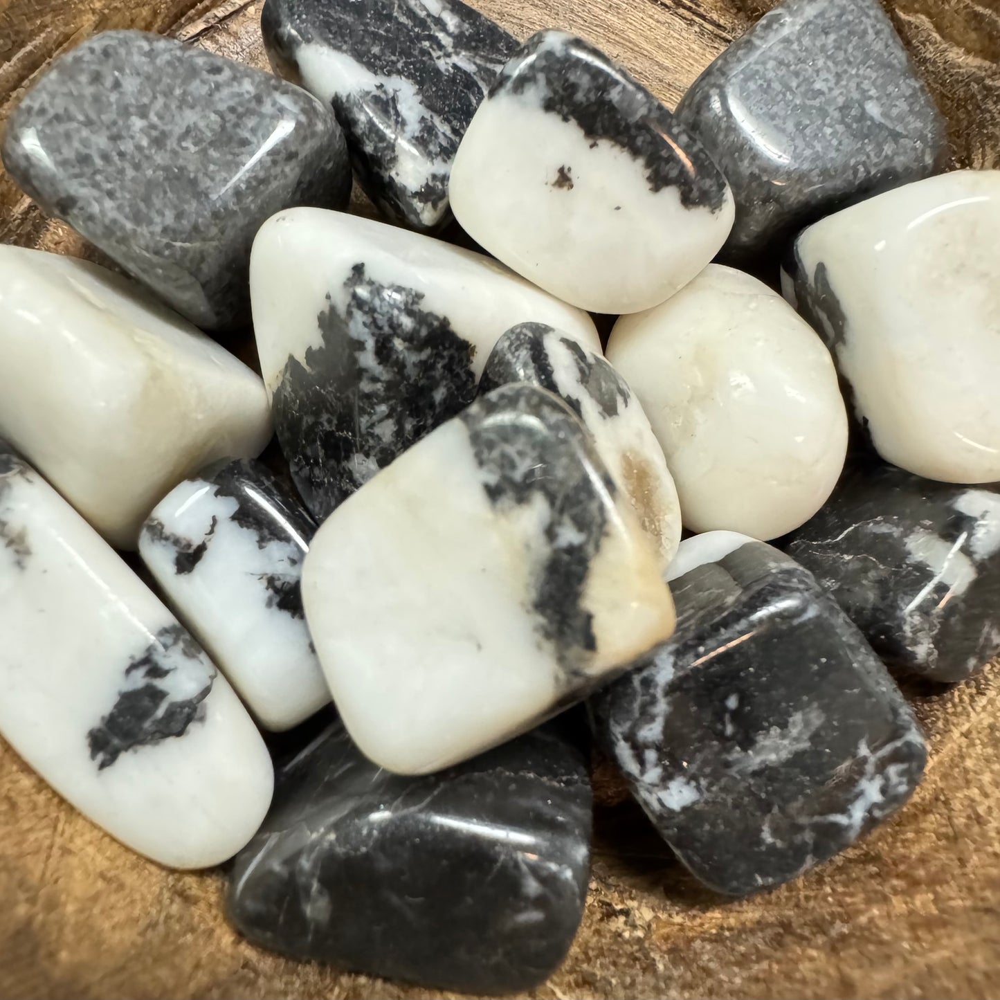 Close-up of black and white marbled stones on a wooden surface