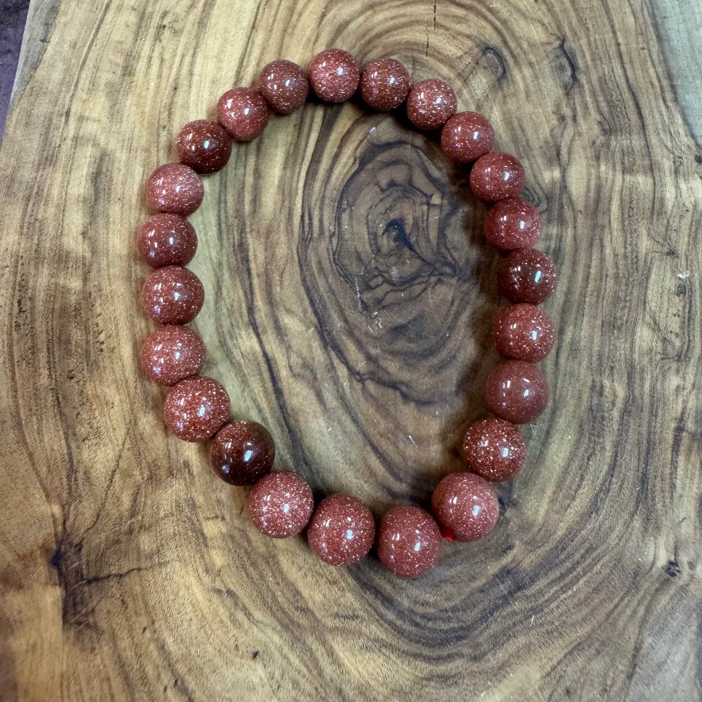Bracelet with red gemstones on a wooden surface