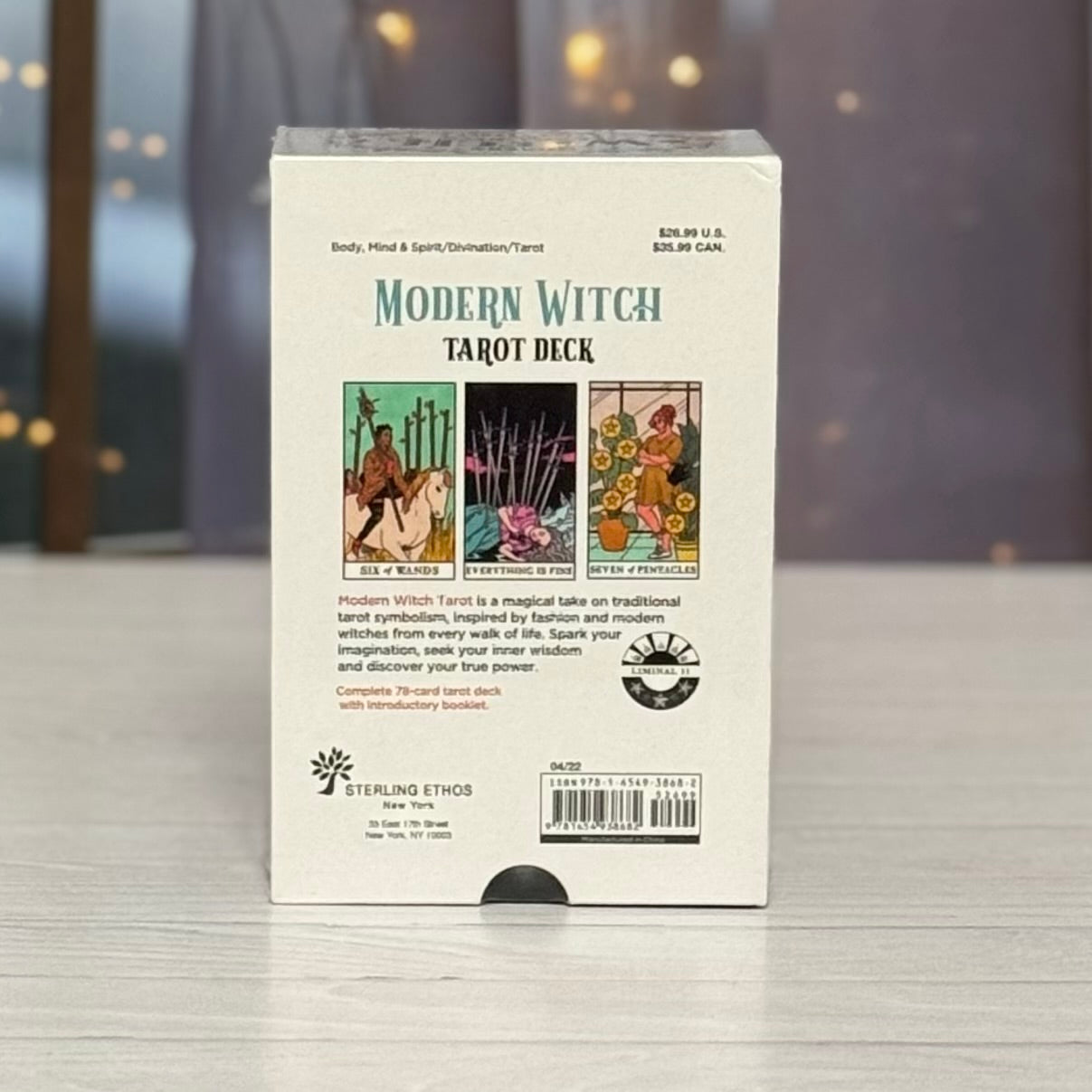 Box of 'Modern Witch Tarot Deck' on a reflective surface with a blurred background