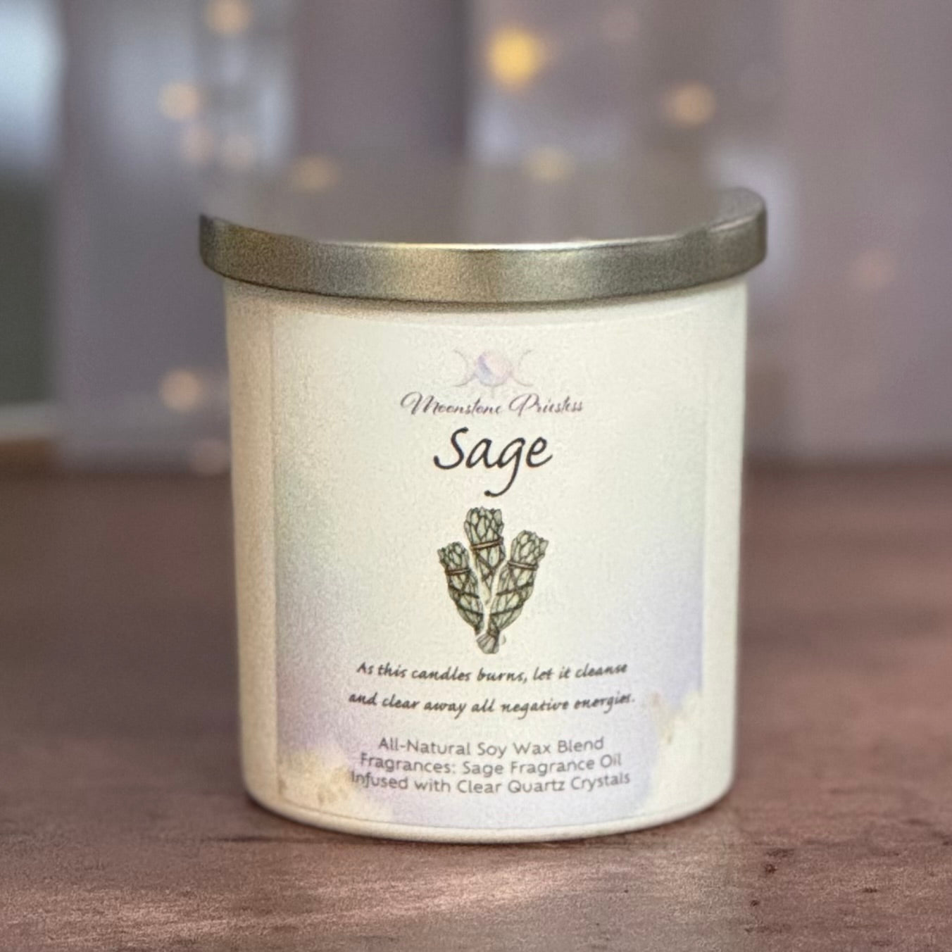 Scented candle labeled 'Sage' with a decorative lid on a wooden surface.