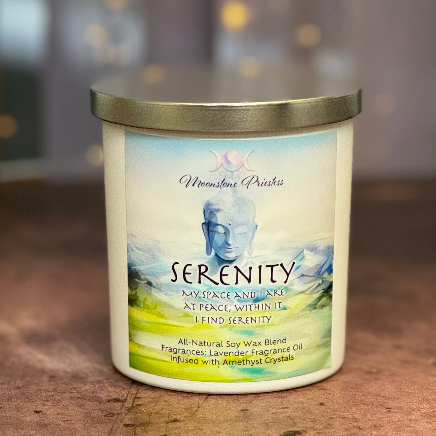 Candle with 'Serenity' label featuring a serene landscape design on a wooden surface.