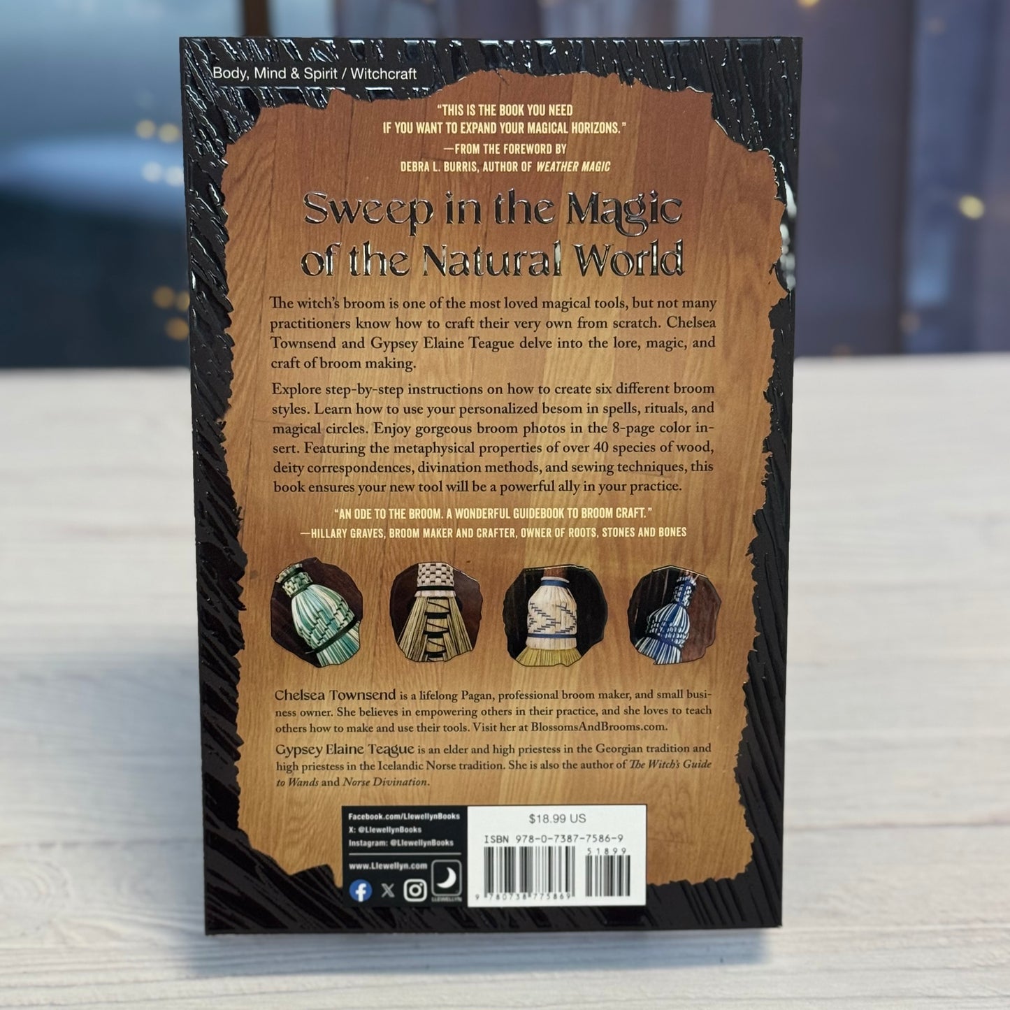 Back cover of a book titled 'Sweep in the Magic of the Natural World' on a reflective surface.