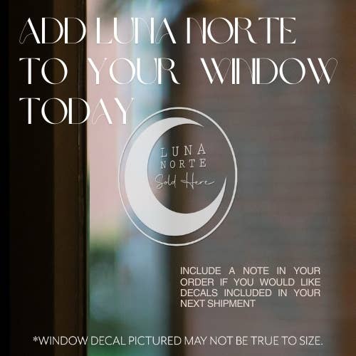 Window decal with Luna Norte logo and text overlay on a blurred window background