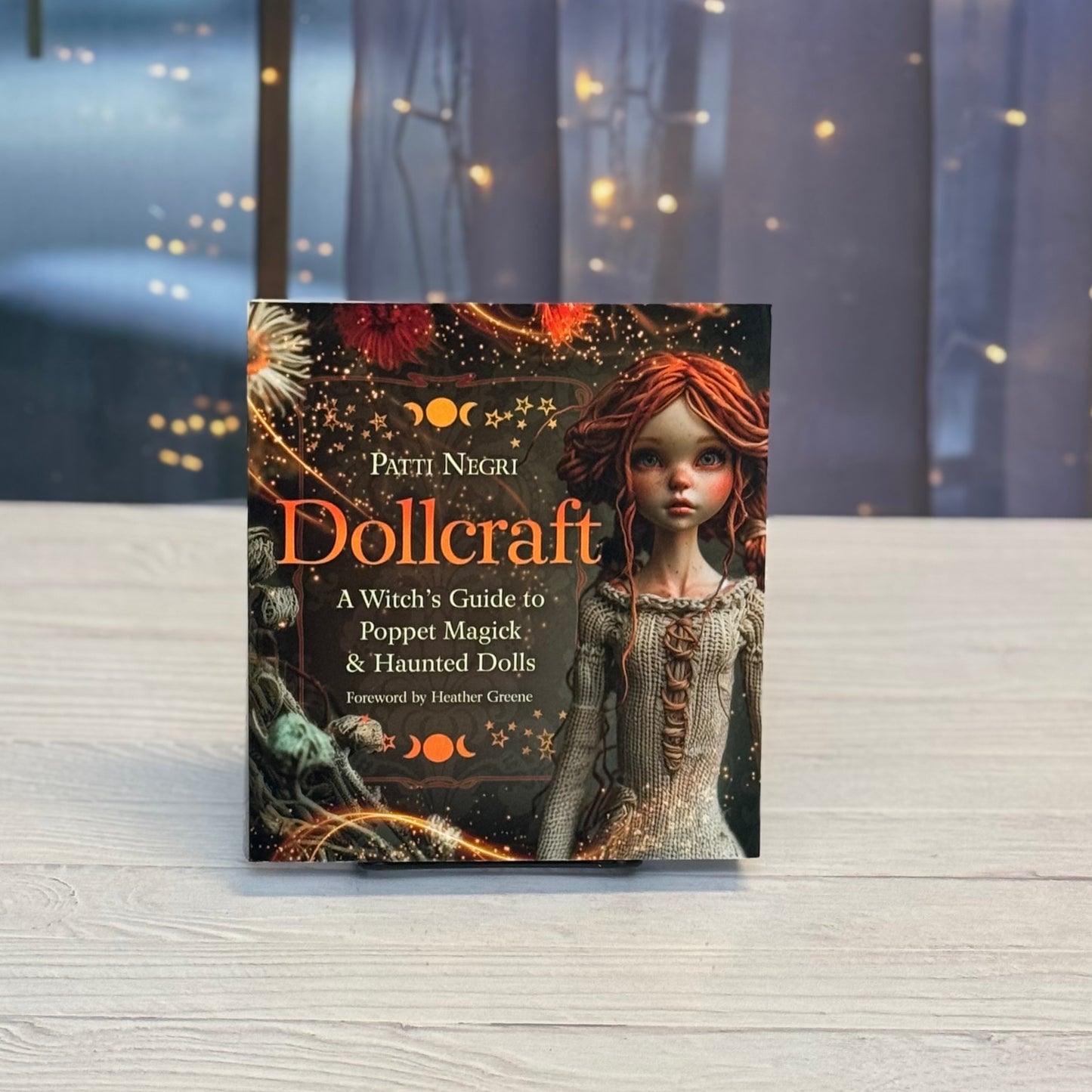 Book titled 'Dollcraft' by Patti Negri on a wooden surface with a blurred background