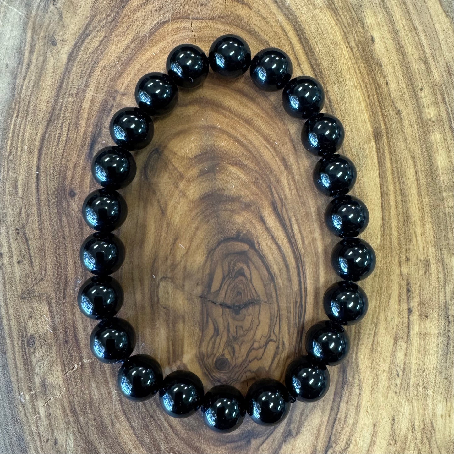 Black beaded bracelet on a wooden surface