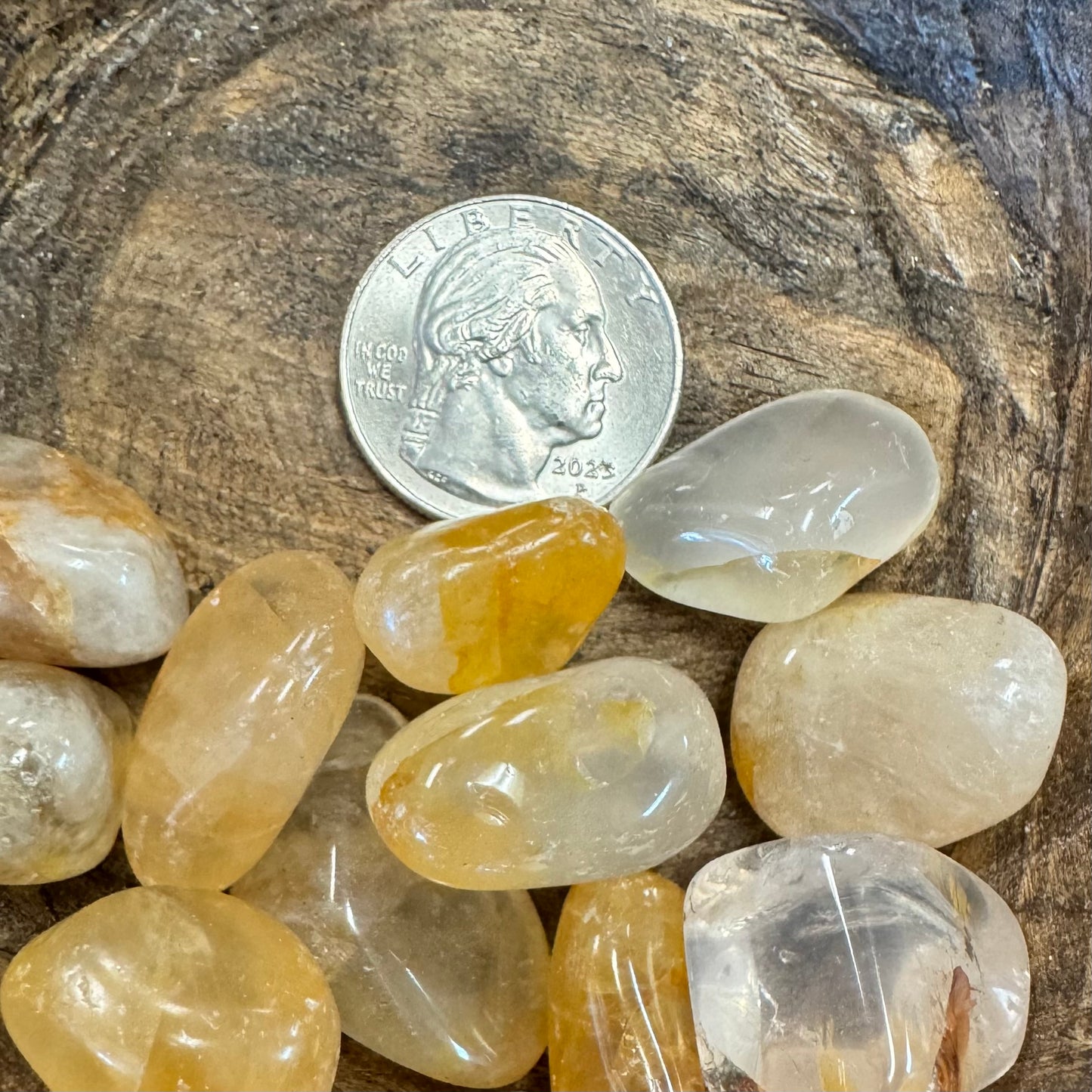 Rocks on a wooden surface with a U.S. quarter coin for scale.