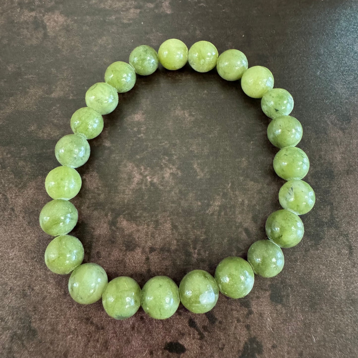 Green beaded bracelet on a brown surface