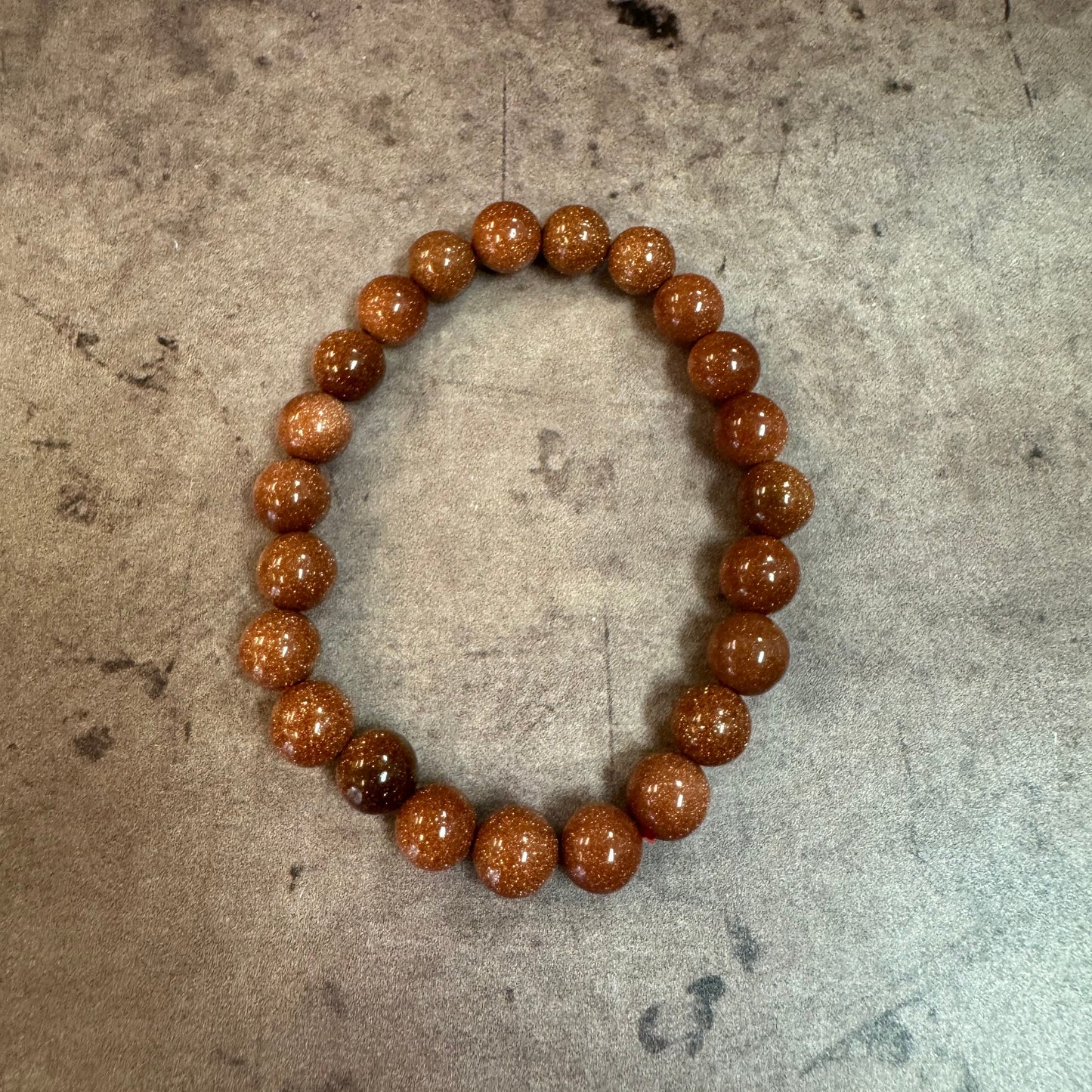 Brown beaded bracelet on a textured surface