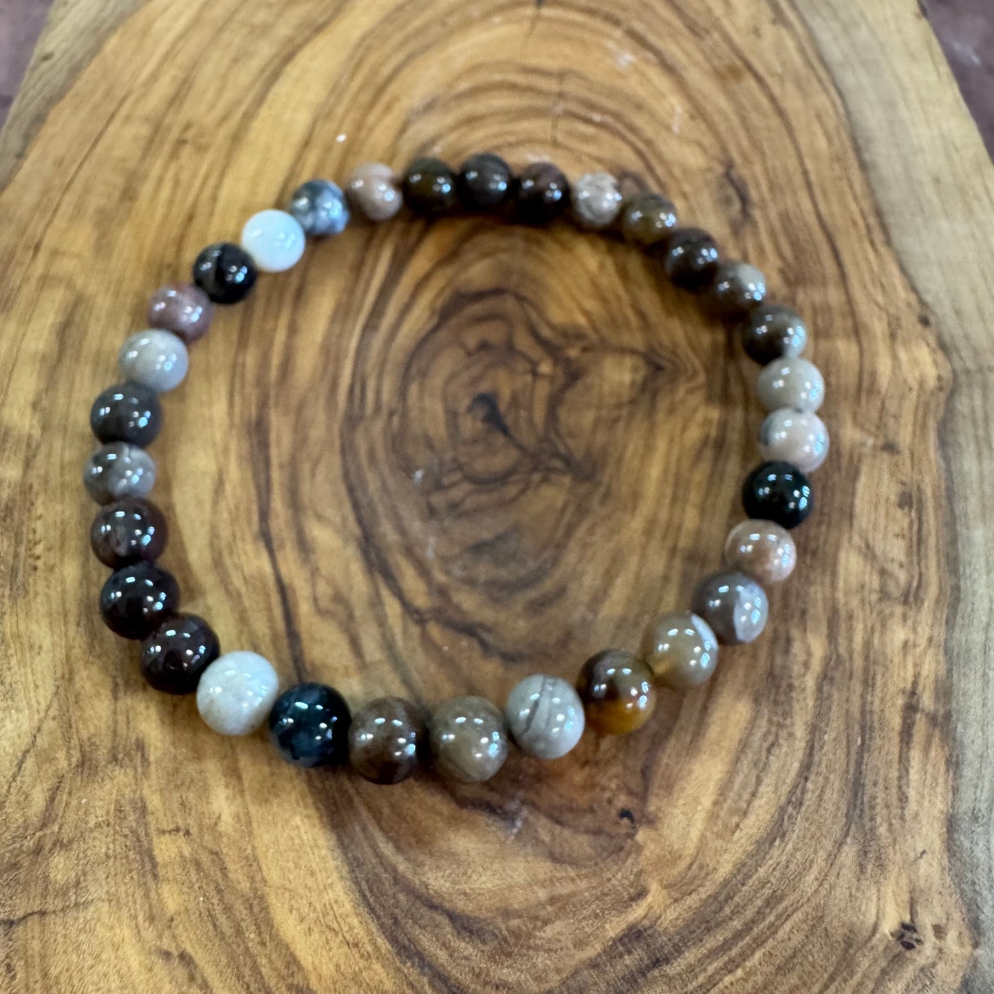 Beaded bracelet with multicolored stones on a wooden surface
