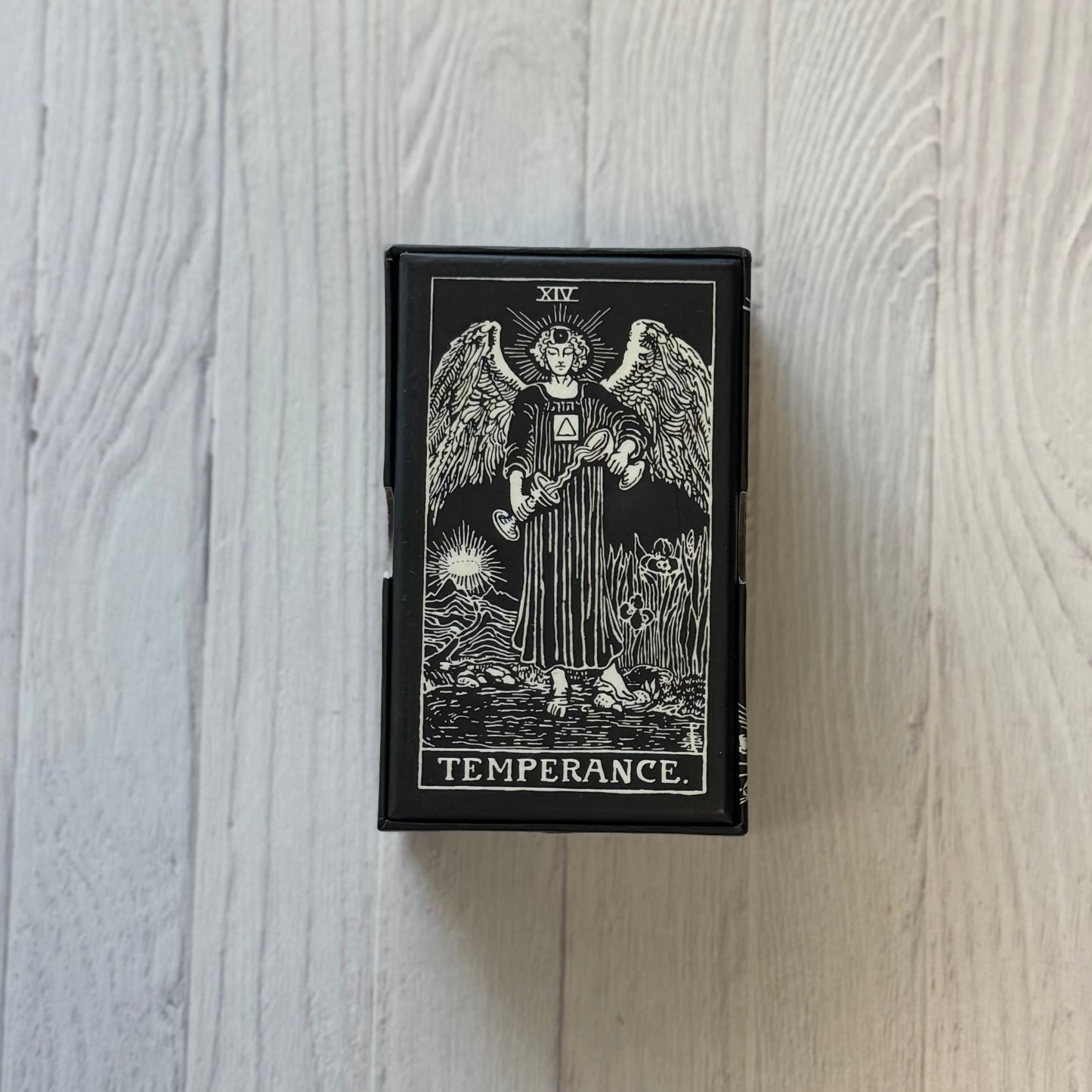 Tarot card featuring an angelic figure with 'Temperance' text on a wooden surface
