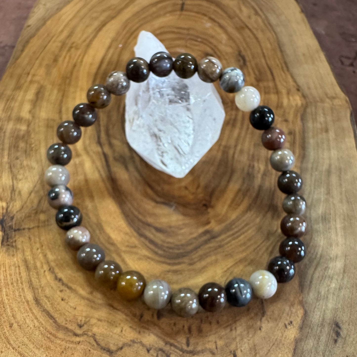 Stones bracelet on a wooden surface with a crystal
