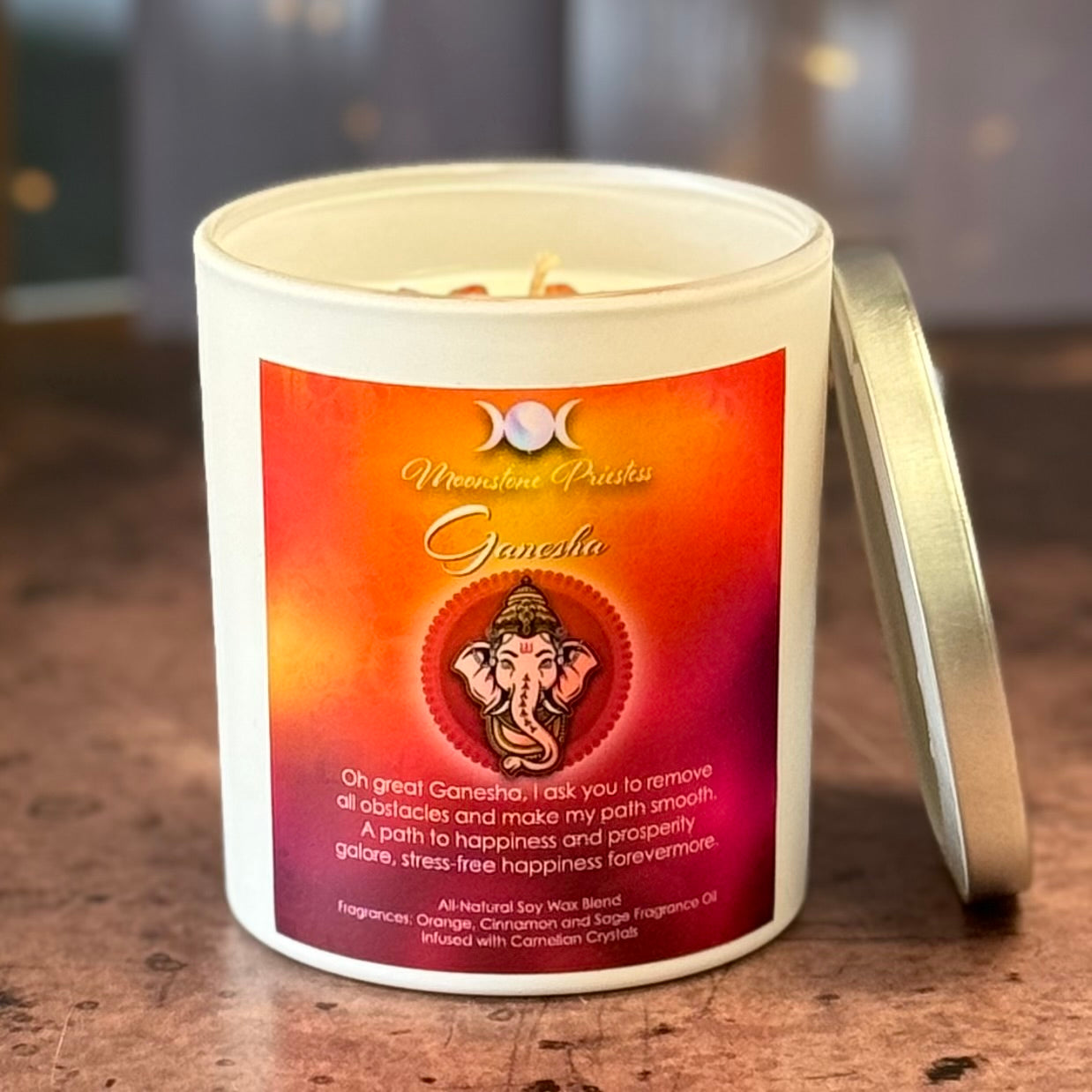 Candle with a Ganesha-themed label on a wooden surface