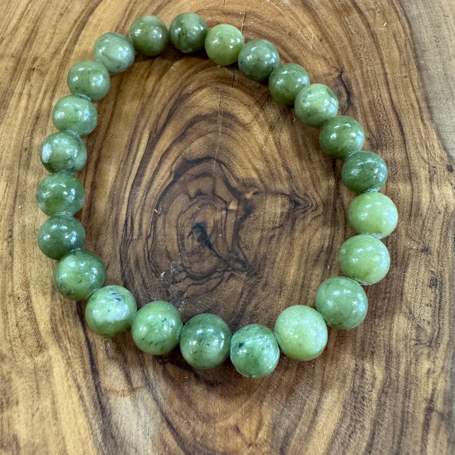 Green beaded bracelet on a wooden surface