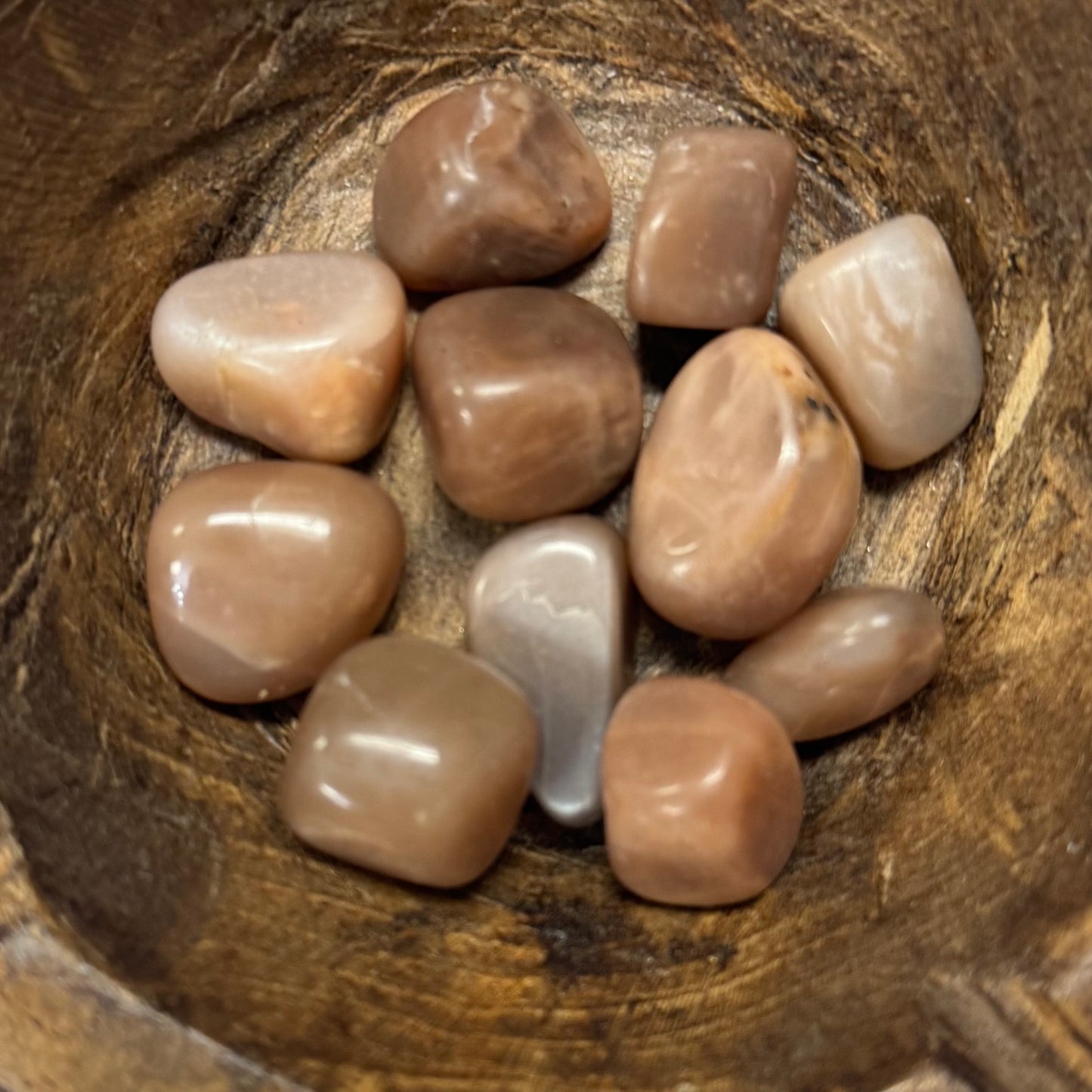 Collection of smooth stones in a wooden bowl