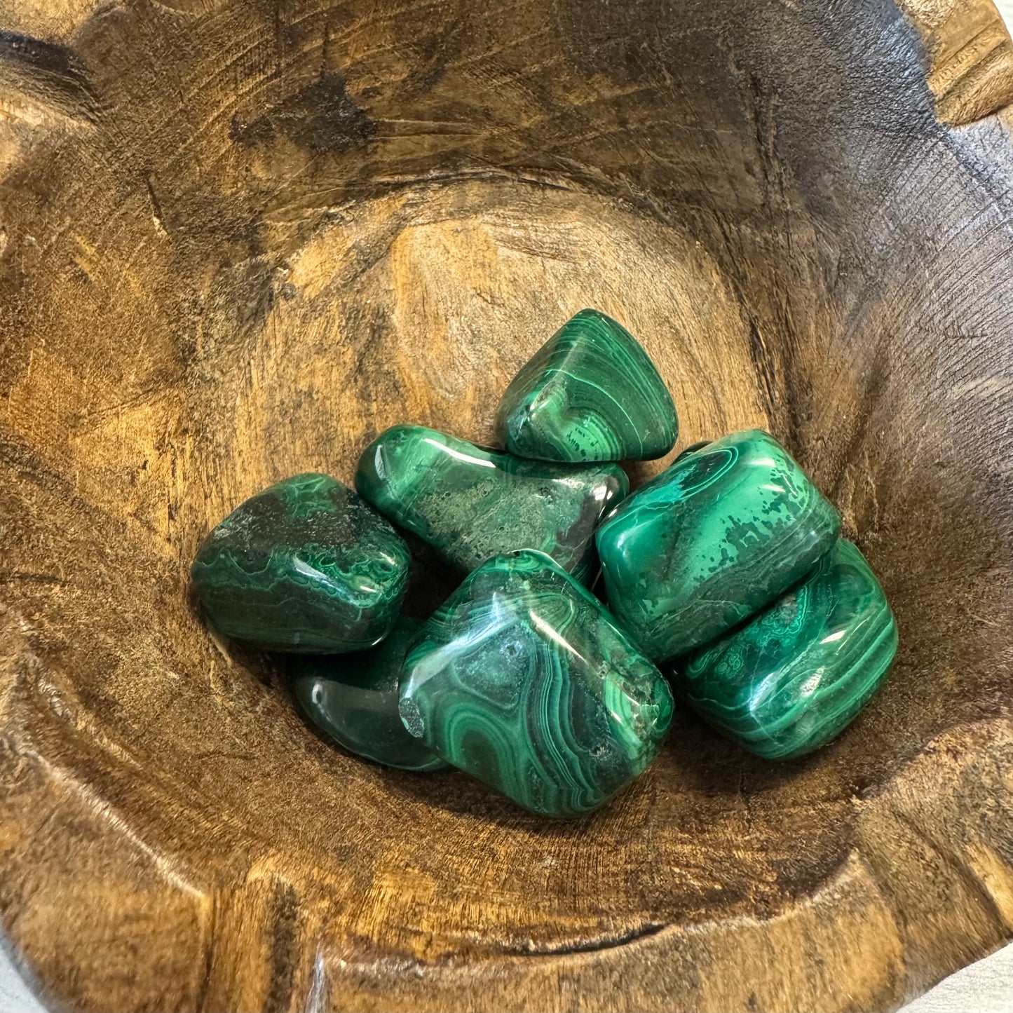 Green marbled stones in a wooden bowl