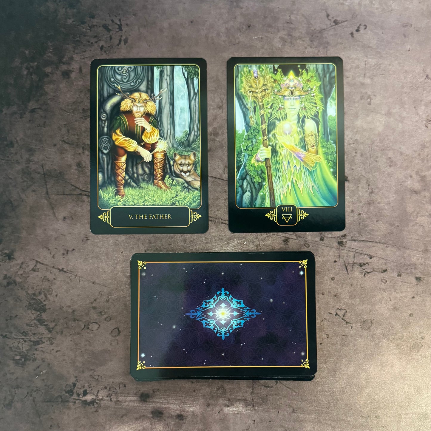 Three tarot cards on a textured surface
