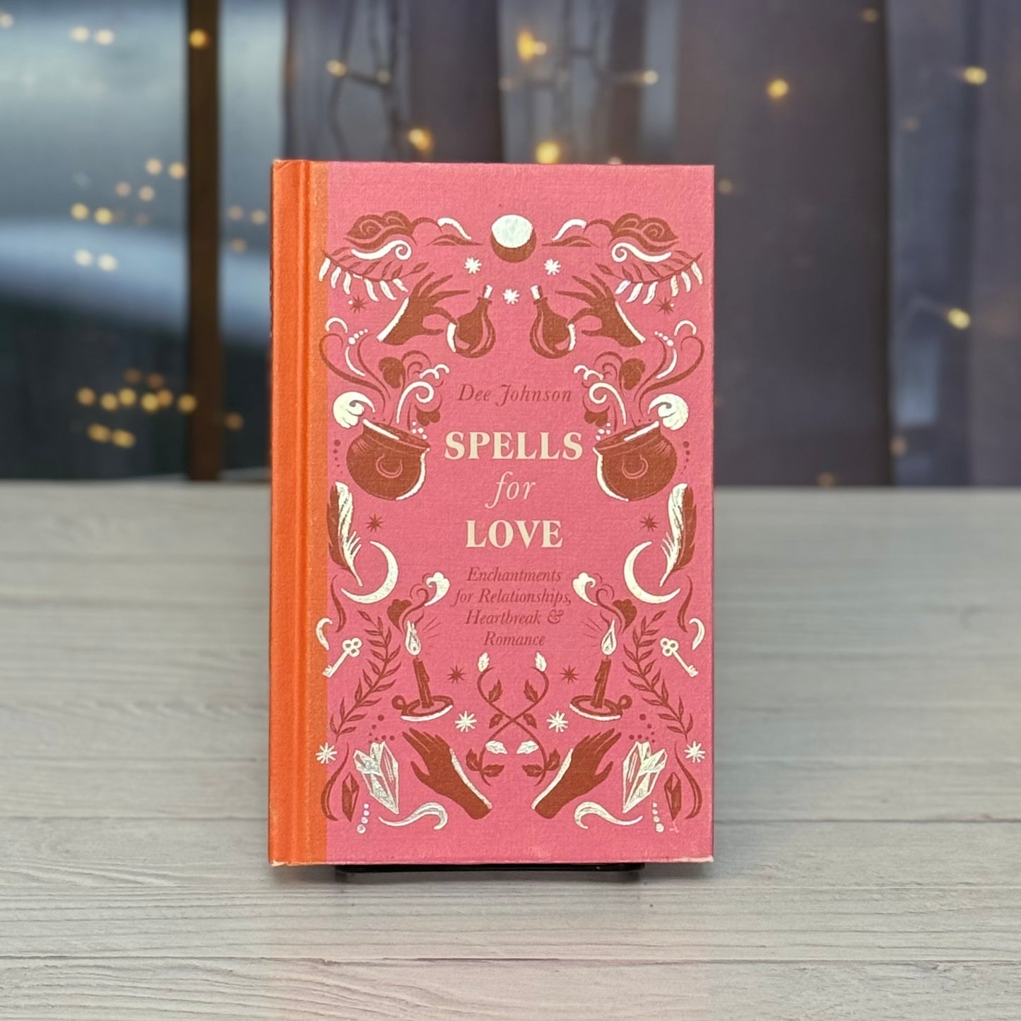 Book titled 'Spells for Love' with decorative cover on a wooden surface