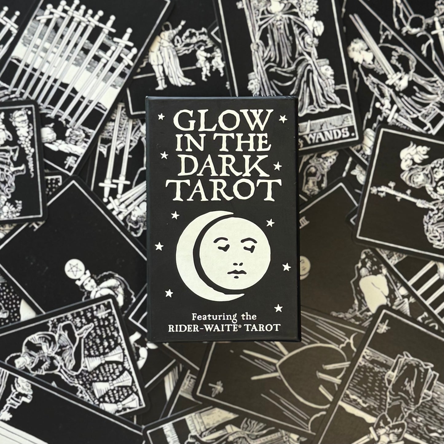 Glow in the Dark Tarot card packaging with tarot cards scattered around