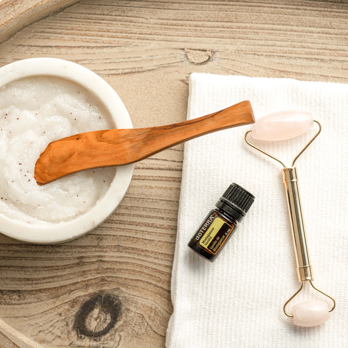 Skincare tools and products on a wooden surface