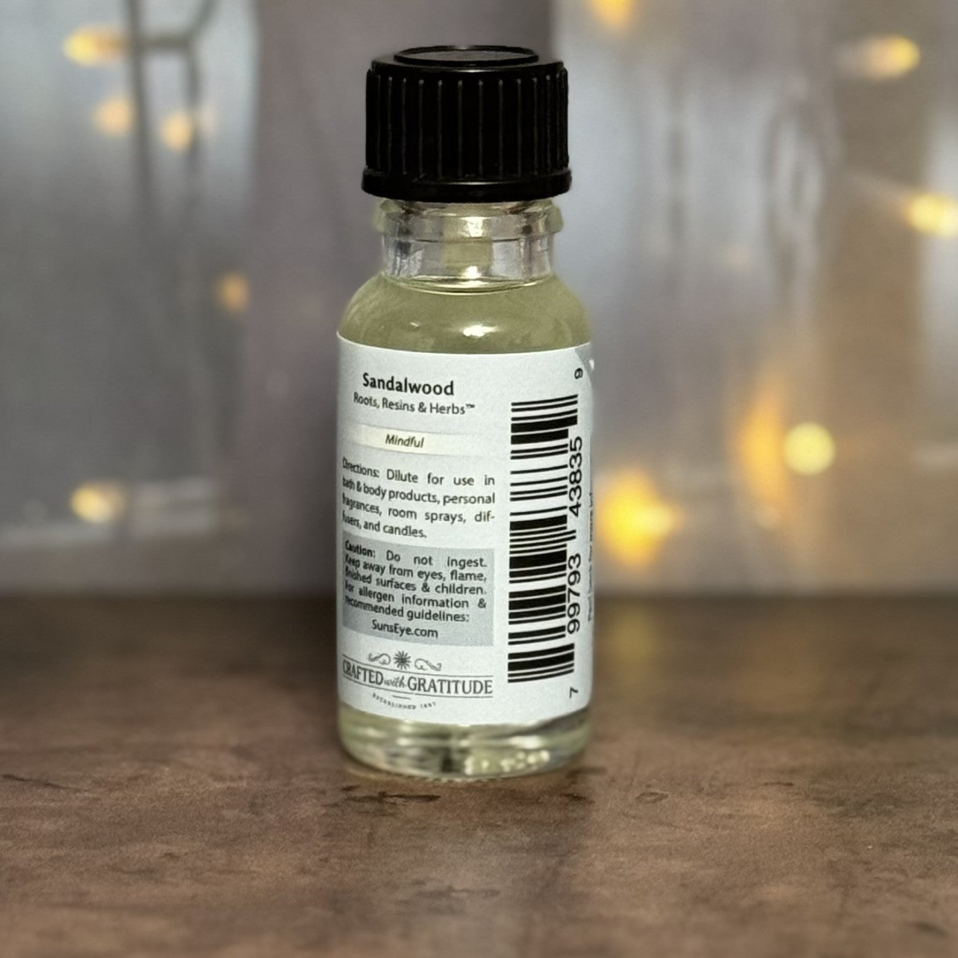 Small bottle of Sandalwood oil with a label on a wooden surface.