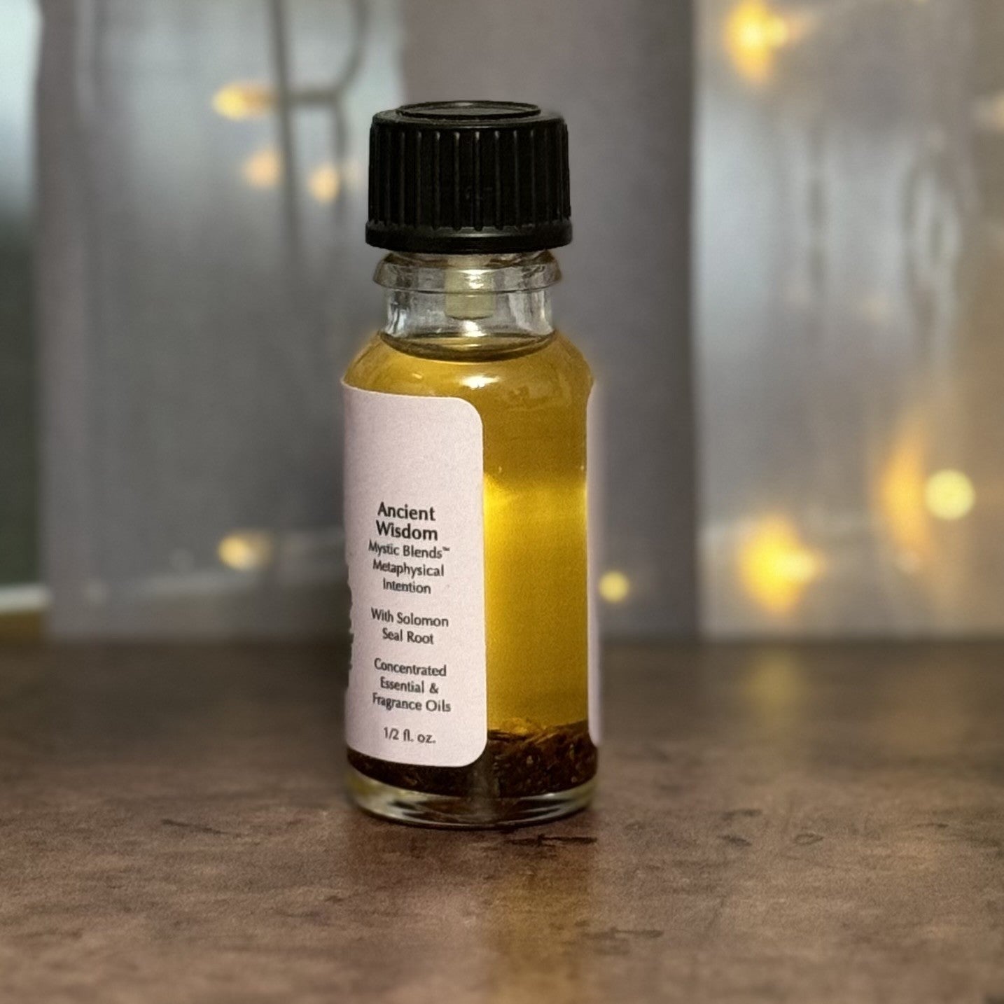 Small glass bottle with yellow liquid and black cap on a wooden surface with a blurred background