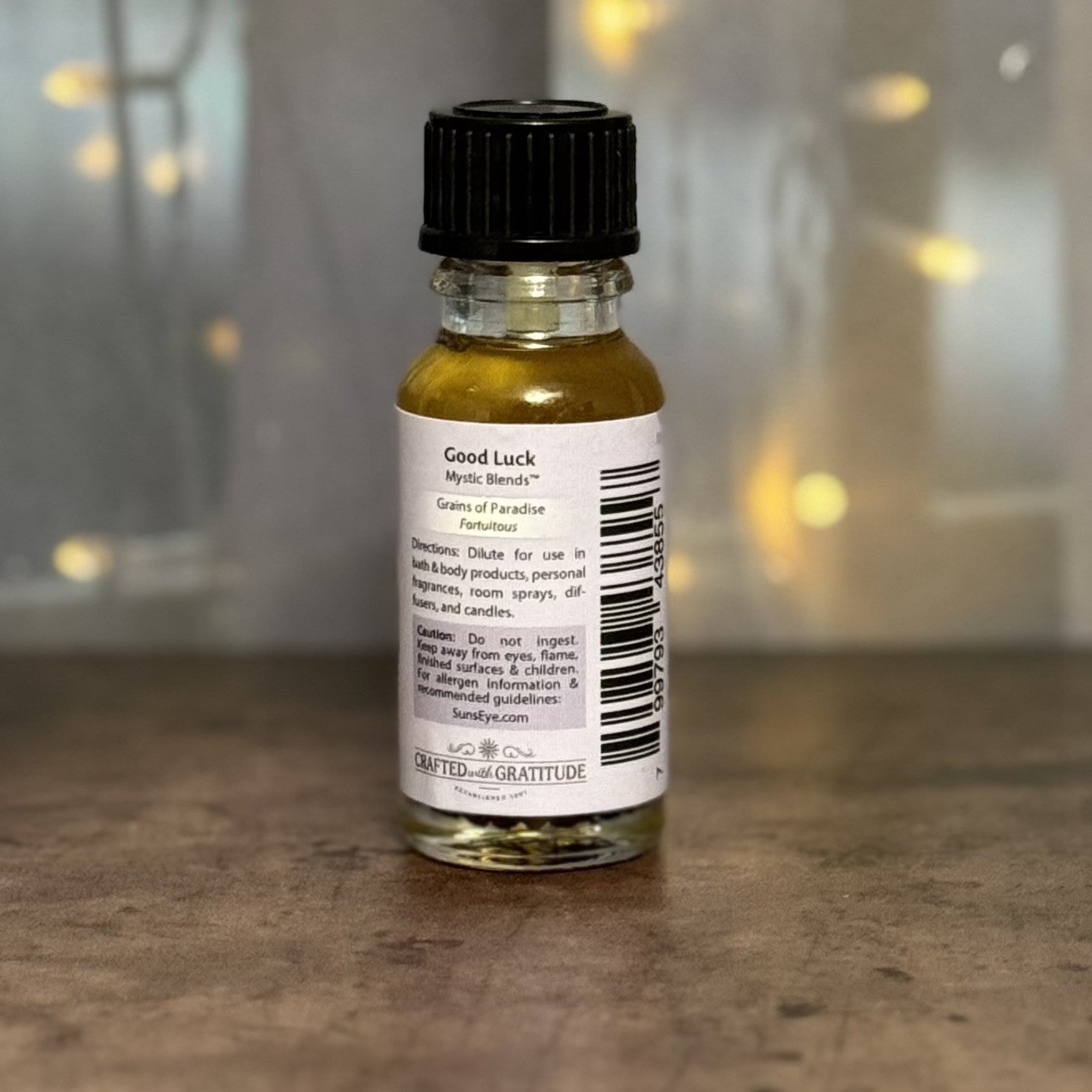 Small bottle with a label on a wooden surface, blurred lights in the background