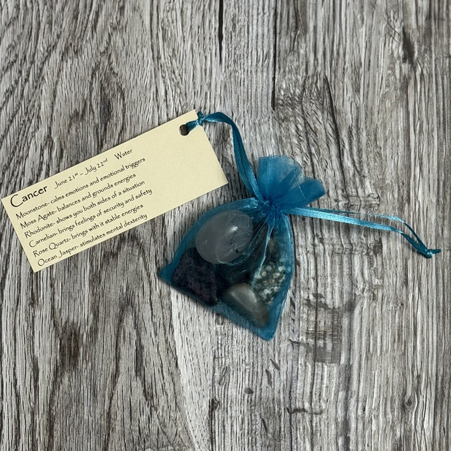 Blue bag with a candle and tag on a wooden surface