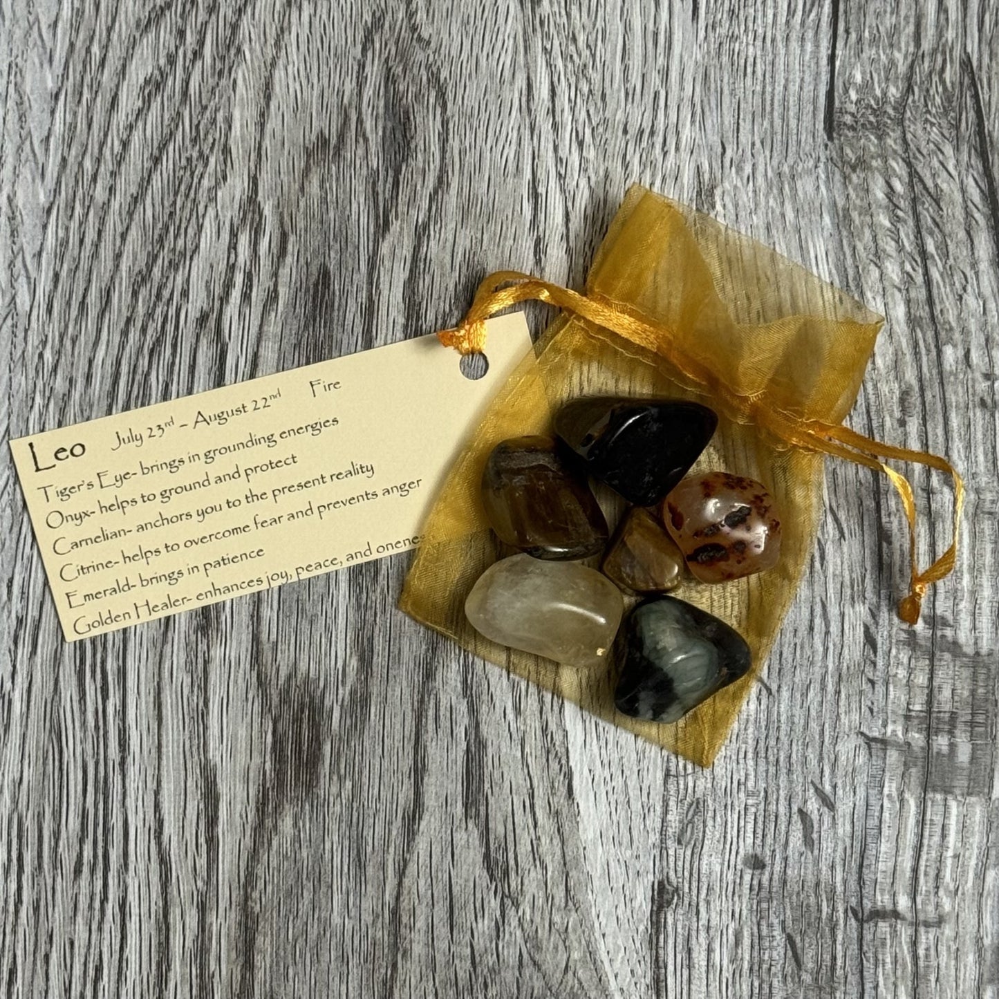 Set of stones in a drawstring bag with a tag on a wooden surface