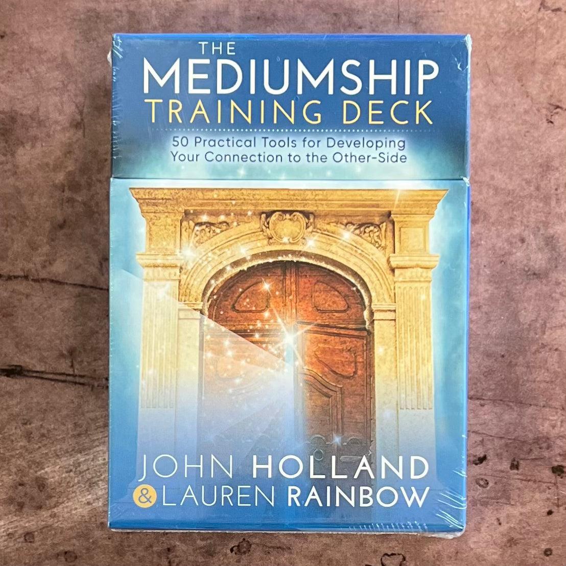 A boxed product titled 'The Mediumship Training Deck' by John Holland and Lauren Rainbow, featuring an image of a spiritual or mystical doorway on the cover.