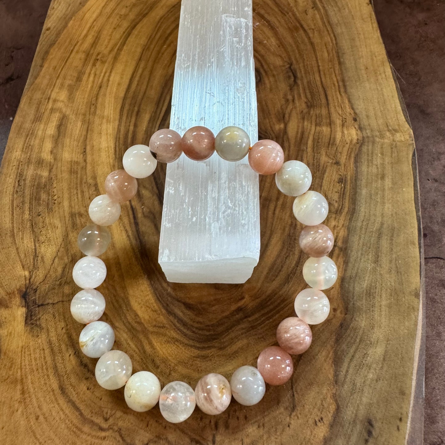 Beaded bracelet on a wooden surface with a crystal