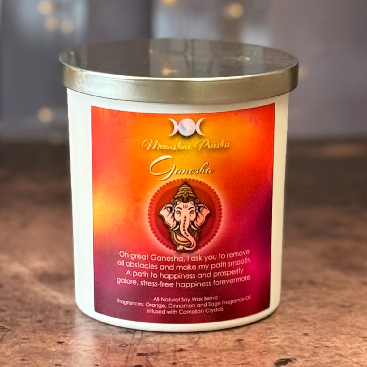 Candle with a Ganesha design and text on a wooden surface