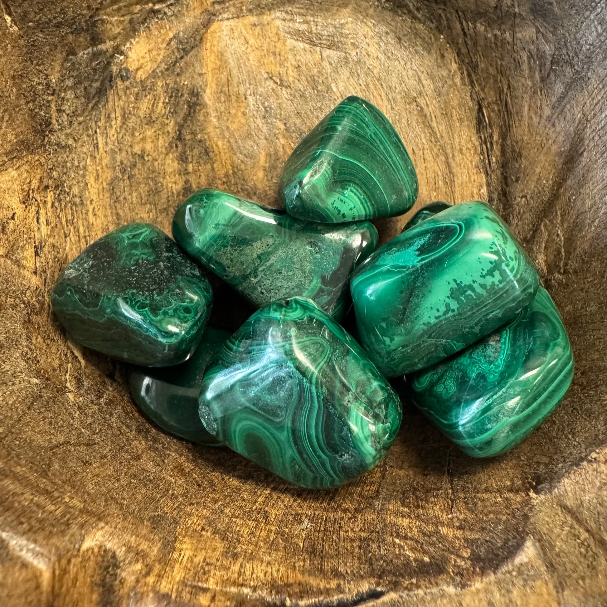 Green malachite stones on a wooden surface