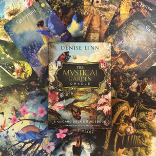 Denise Linn's 'The Mystical Garden Oracle' book surrounded by colorful oracle cards with nature-themed illustrations.