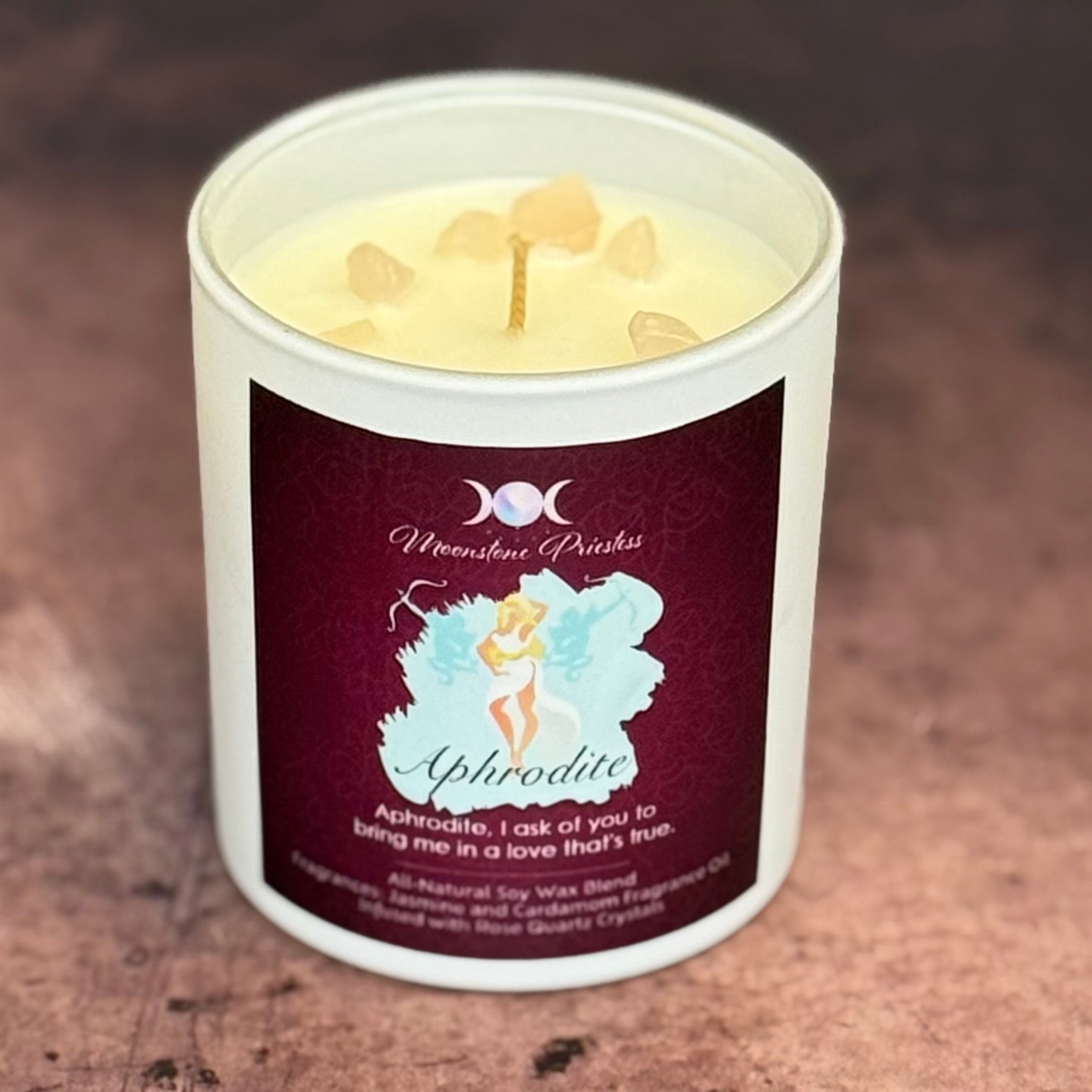 Candle with a label featuring a fairy design on a textured surface