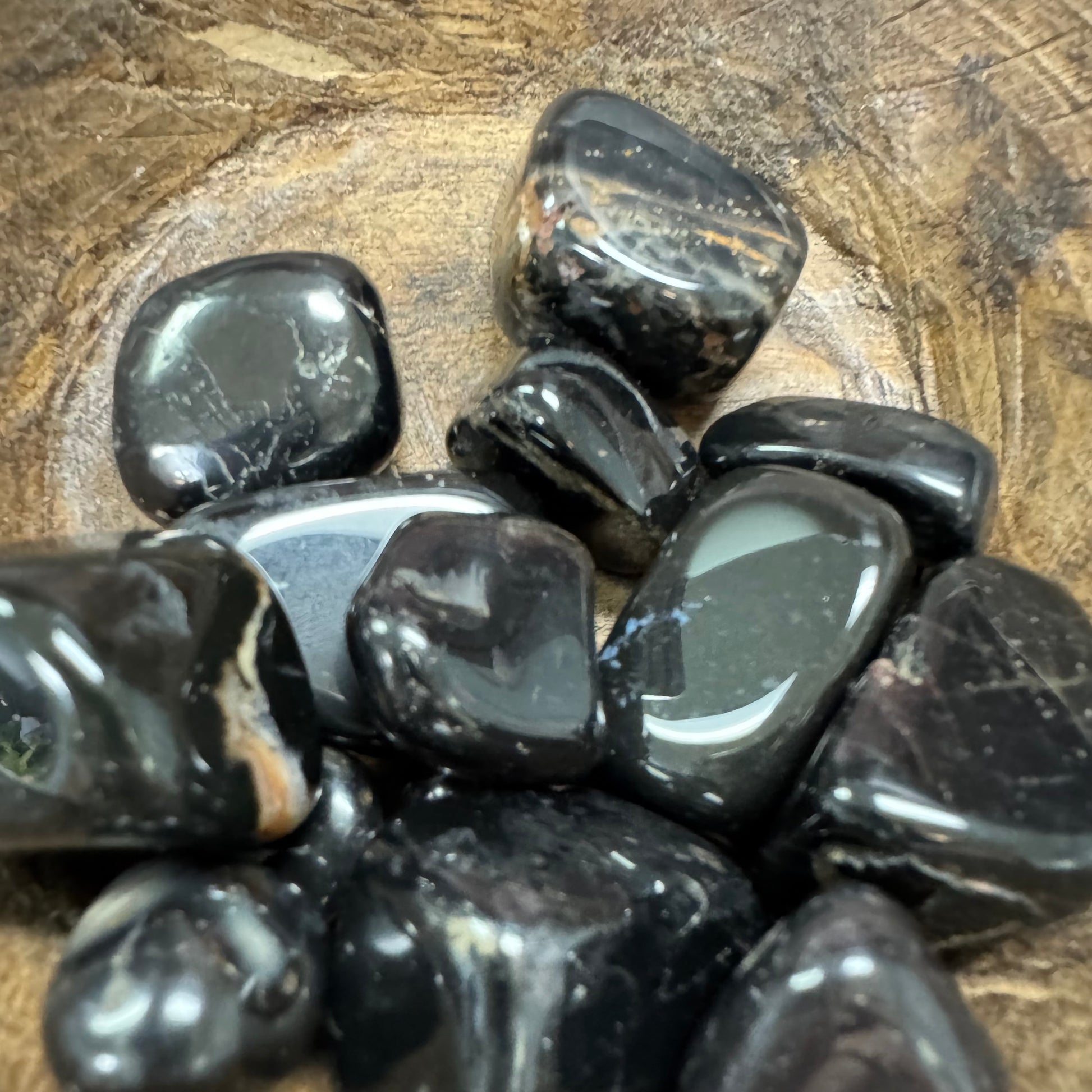 Collection of black stones on a wooden surface