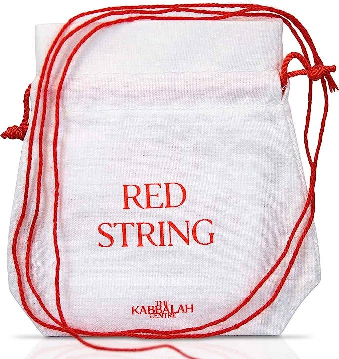 White drawstring bag with red string and 'Red String' text, featuring Kabbalah Centre branding.