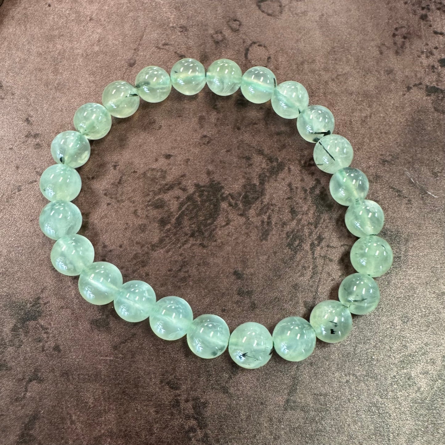 Green beaded bracelet on a textured surface