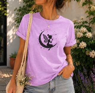 Heather Prism Lilac Fairy on Crescent Moon t-shirt with a black fairy and stars design, worn outdoors