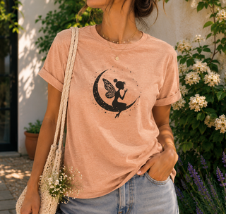 Heather Peach Fairy on Crescent Moon t-shirt with a black fairy and stars design, worn outdoors