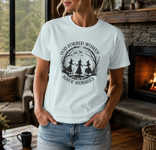 White God Forbid Women Have Hobbies t-shirt with a vintage moonlit forest design of two women dancing, worn in a cozy living room