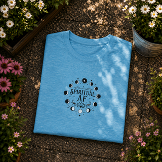 Folded Heather Aqua Spiritual AF moon phase tee on a stone surface with flowers