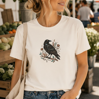 Crow Moon tee featuring a hand-drawn crow with crescent moons and florals, worn by a model