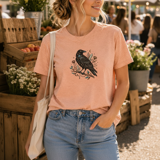 Crow Moon tee featuring a hand-drawn crow with crescent moons and florals, worn by a model