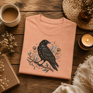 Folded Crow Moon tee featuring a hand-drawn crow with crescent moons and florals, styled in a flatlay