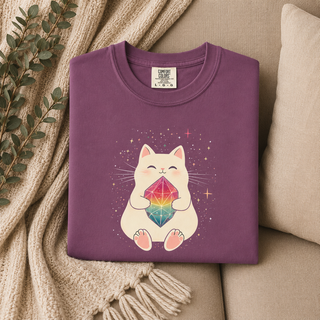 Folded Berry purple Crystal Cat tee with a cute cat holding a rainbow gem on a beige surface