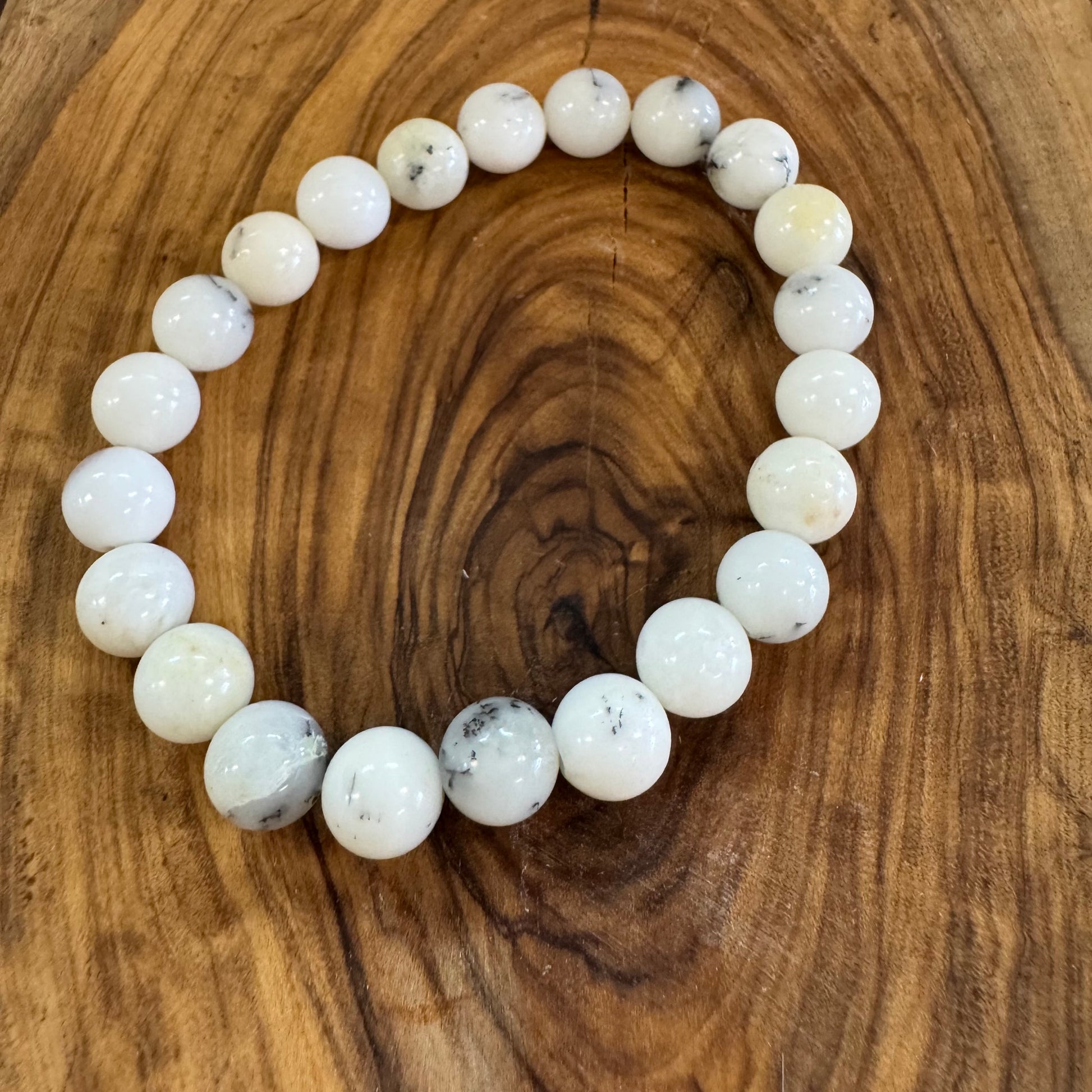 White beaded bracelet on a wooden surface