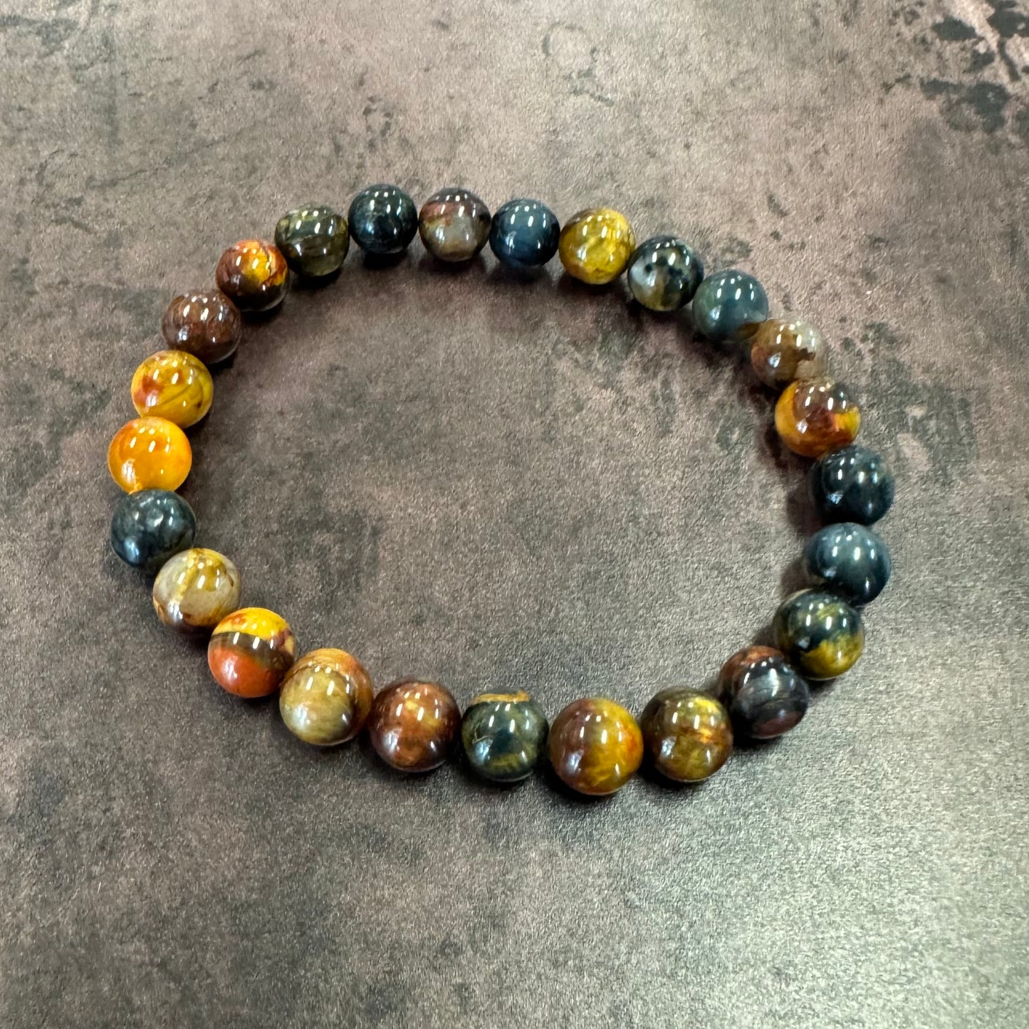 Multicolored beaded bracelet on a textured gray surface