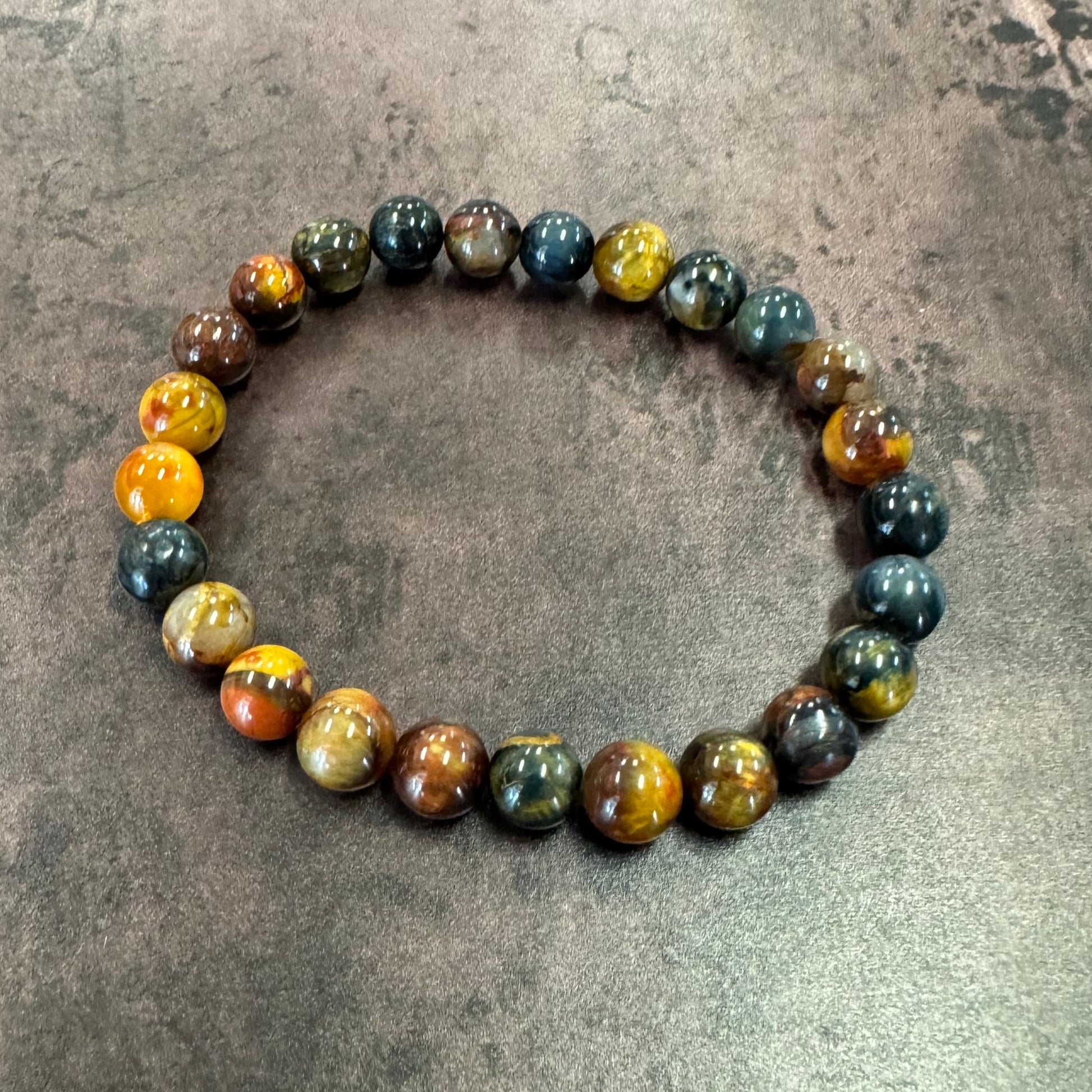 Multicolored beaded bracelet on a textured gray surface